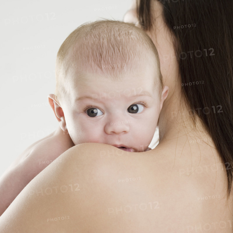 Baby looking over mother’s shoulder. Date : 2006