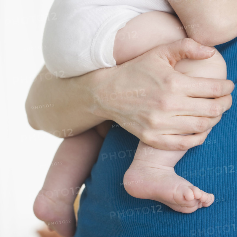 Close up of baby’s legs being held by mother. Date : 2006