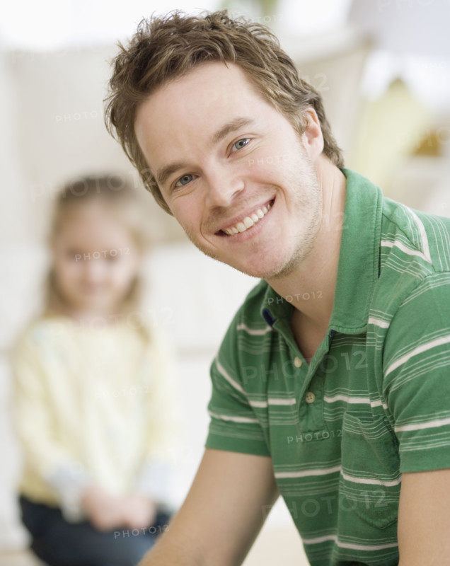 Father smiling with daughter in background. Date : 2007