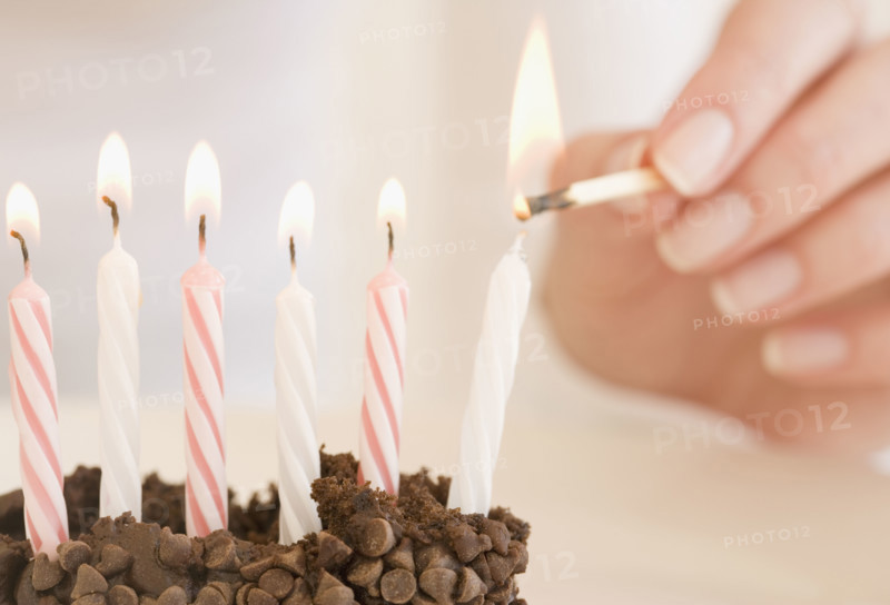Woman lighting birthday candles. Date : 2007