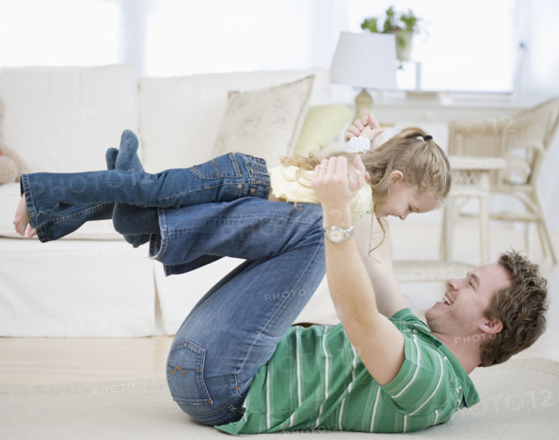 Father and daughter playing on floor. Date : 2007