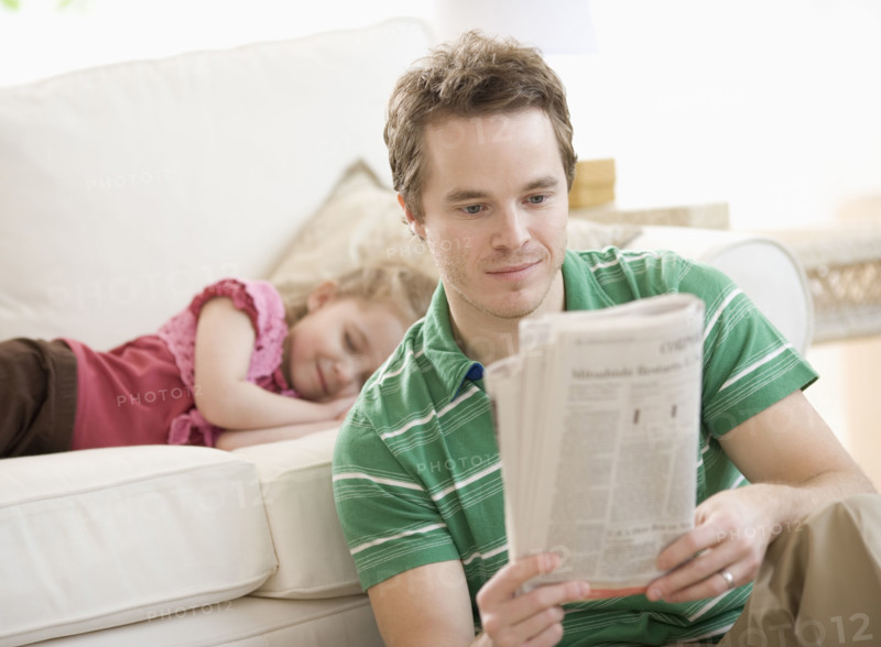 Father and daughter relaxing in livingroom. Date : 2007