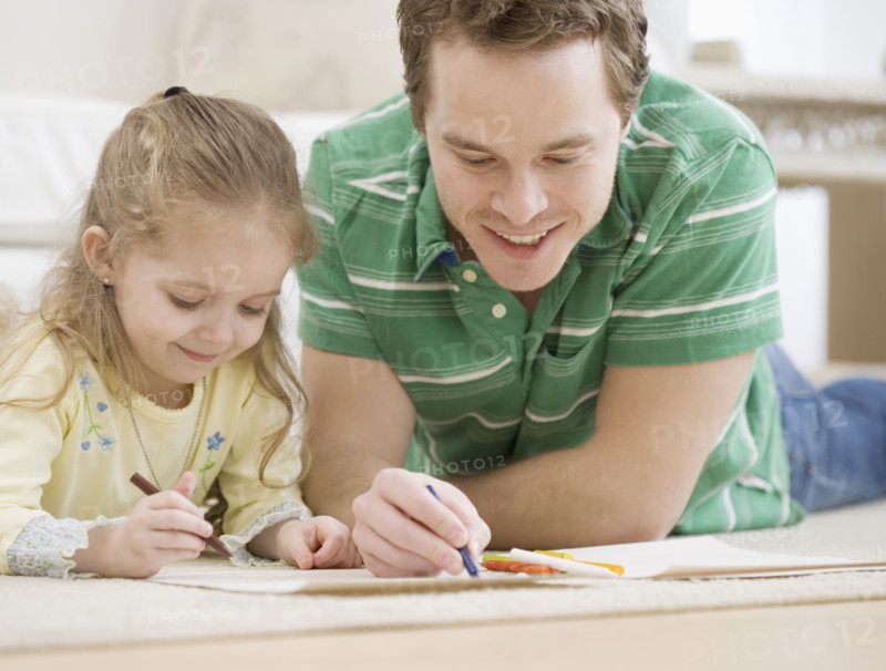 Father and daughter coloring on floor. Date : 2007