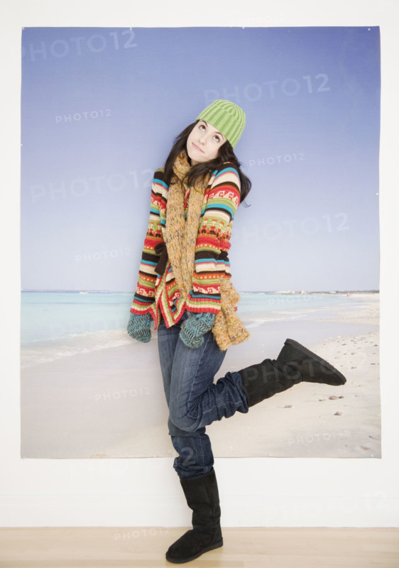 Woman in winter clothing in front of beach picture. Date : 2007