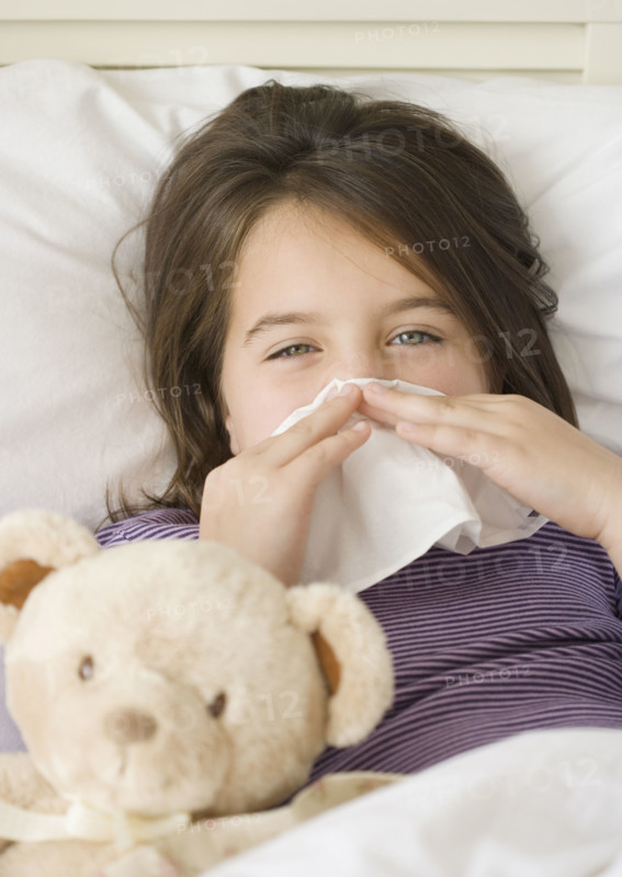 Close up of girl blowing nose in bed. Date : 2006