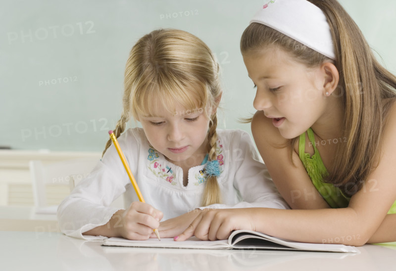 Girl helping classmate at desk. Date : 2006