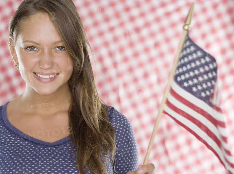Young woman smiling and holding American flag. Date : 2006