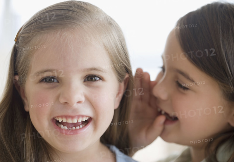 Close up of sisters telling secret. Date : 2006