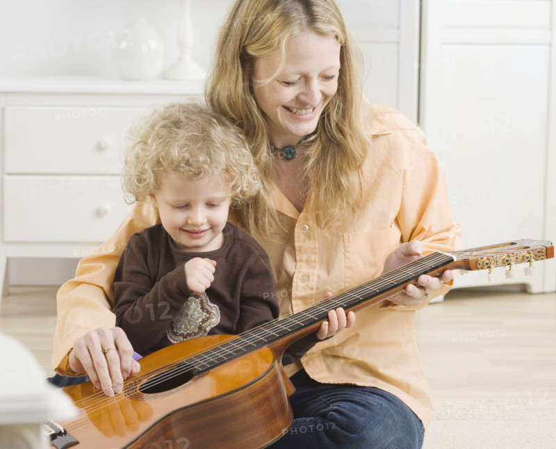 Mother and child playing with guitar. Date : 2006
