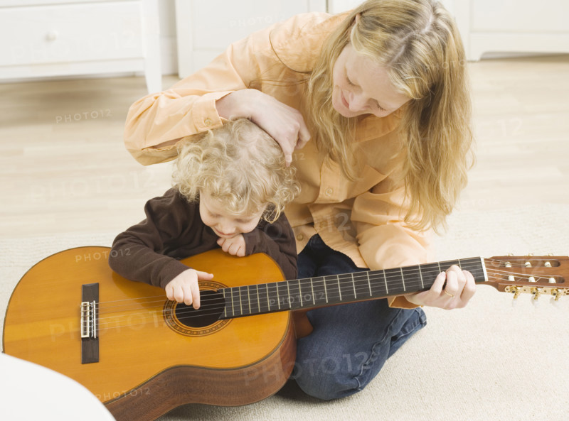 Mother and child playing with guitar. Date : 2006