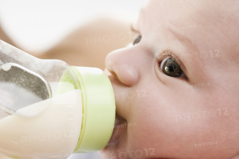 Close up of baby drinking from bottle. Date : 2006