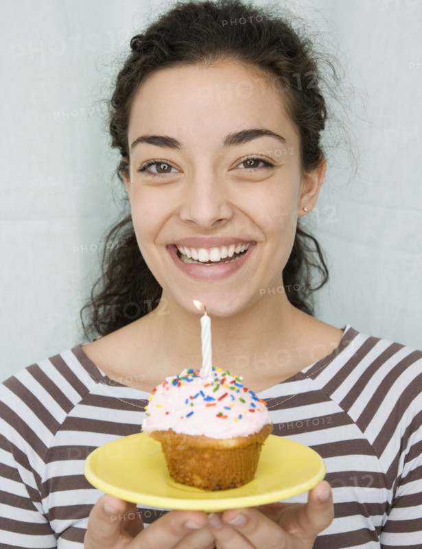 Woman holding cupcake with candle. Date : 2007