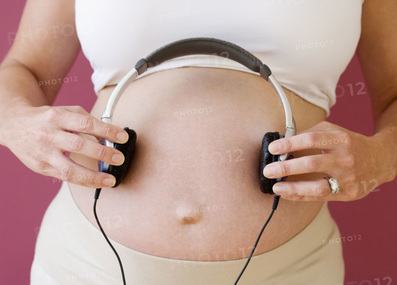 Pregnant woman holding headphones on belly. Date : 2007