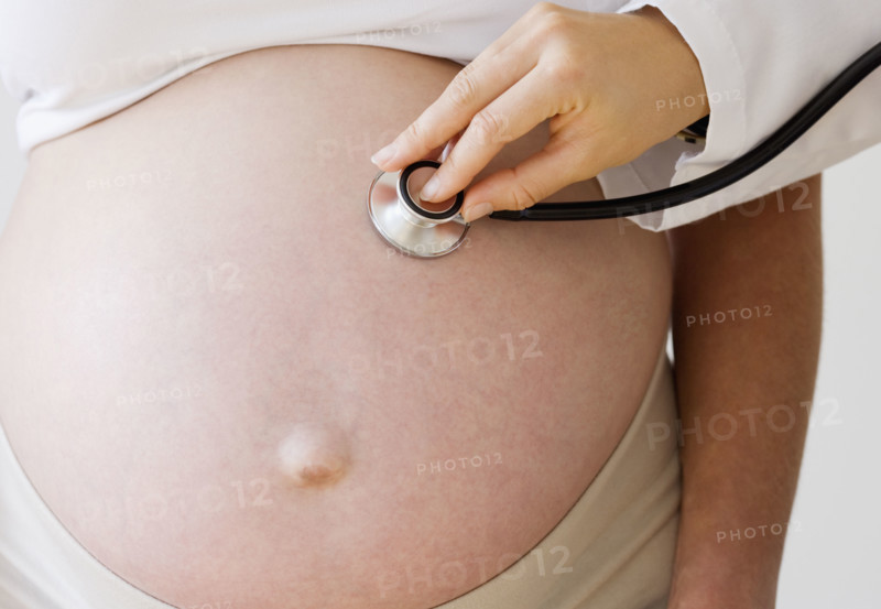 Pregnant woman with stethoscope on belly. Date : 2007