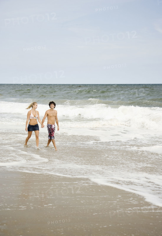 Couple walking in ocean surf. Date : 2007