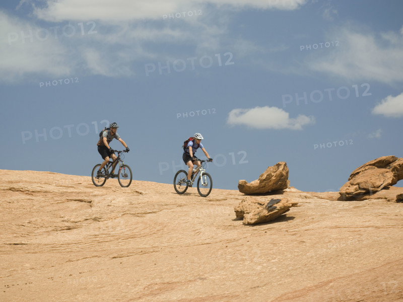 Couple riding mountain bikes in desert. Date : 2007