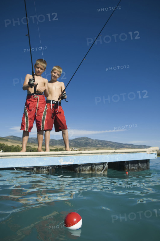 Brothers fishing off dock in lake, Utah, United States. Date : 2007