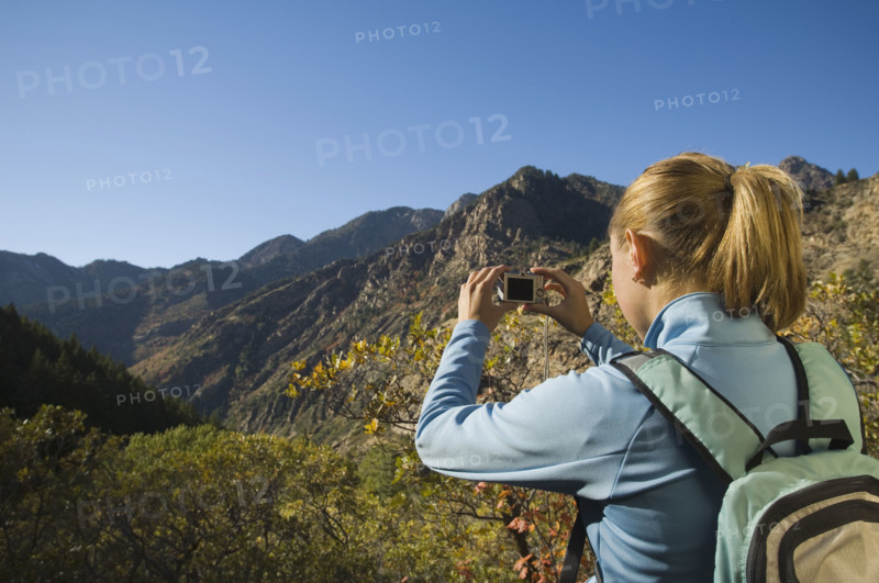 Woman taking photograph of valley, Utah, United States. Date : 2007