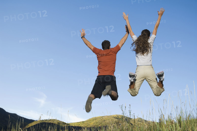 Rear view of couple jumping, Utah, United States. Date : 2007