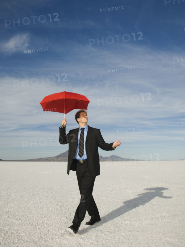 Businessman walking with umbrella, Salt Flats, Utah, United States. Date : 2007