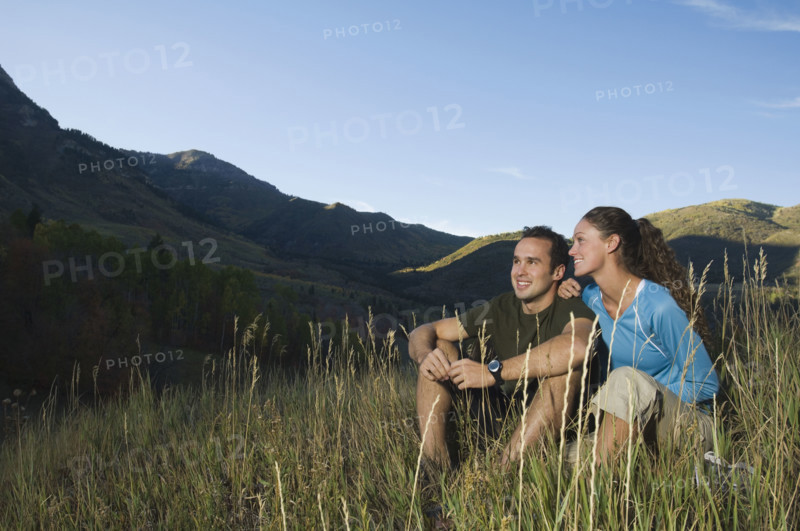 Couple sitting on hillside, Utah, United States. Date : 2007