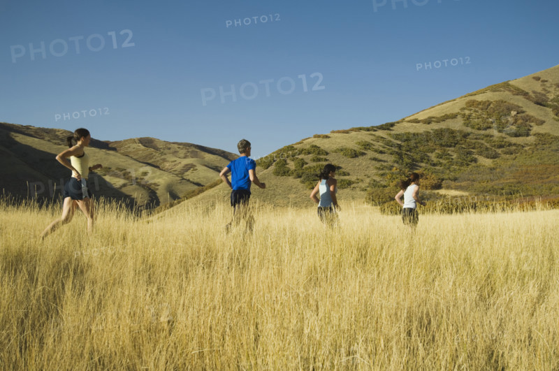 Group of people running in field, Utah, United States. Date : 2007