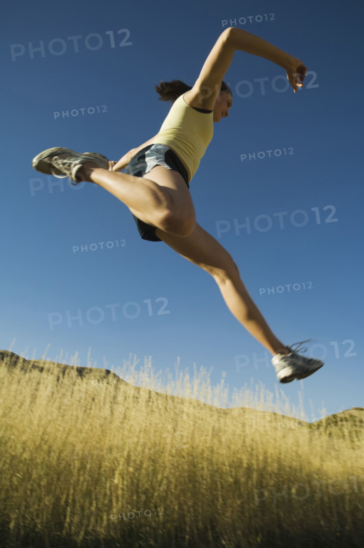Low angle view of woman jumping, Salt Flats, Utah, United States. Date : 2007