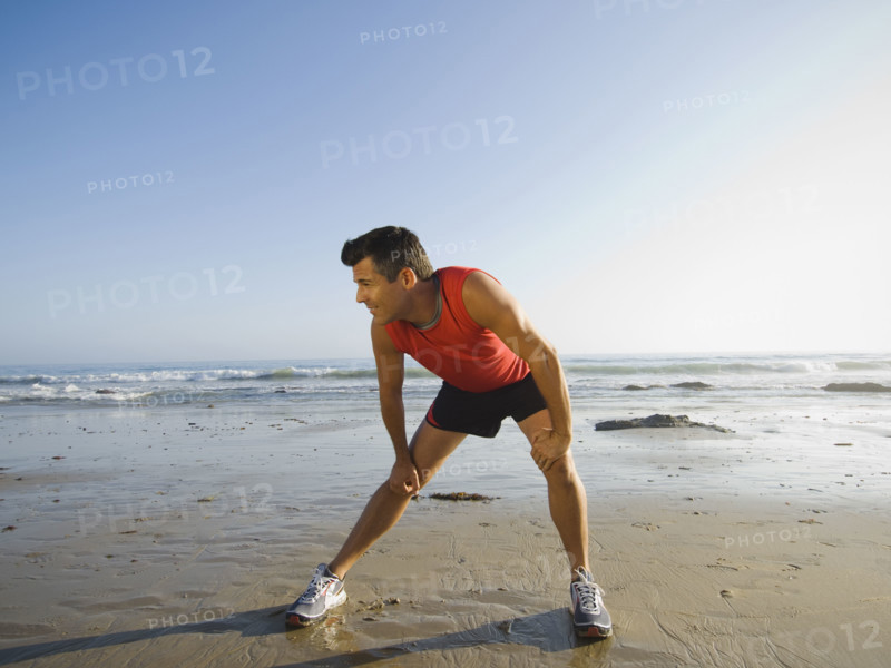 Man stretching at beach. Date : 2007