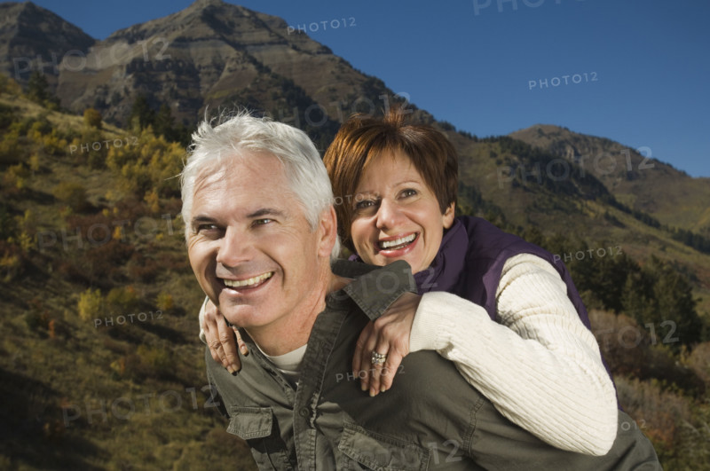 Senior man giving wife piggy back ride, Utah, United States. Date : 2007