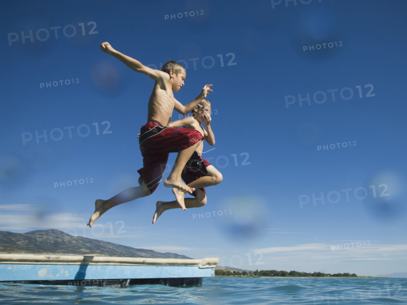 Brothers jumping off dock into lake, Utah, United States. Date : 2007