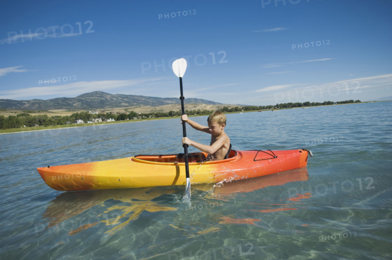 Boy paddling in canoe on lake, Utah, United States. Date : 2007