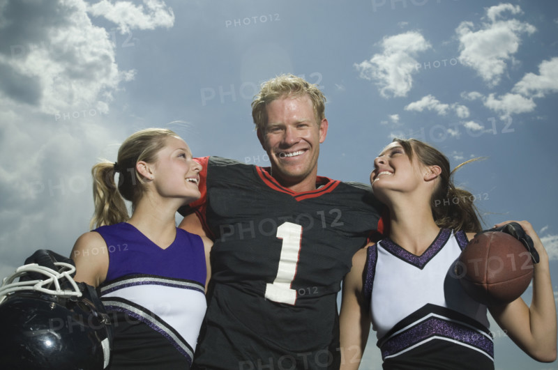 Football player hugging cheerleaders. Date : 2007