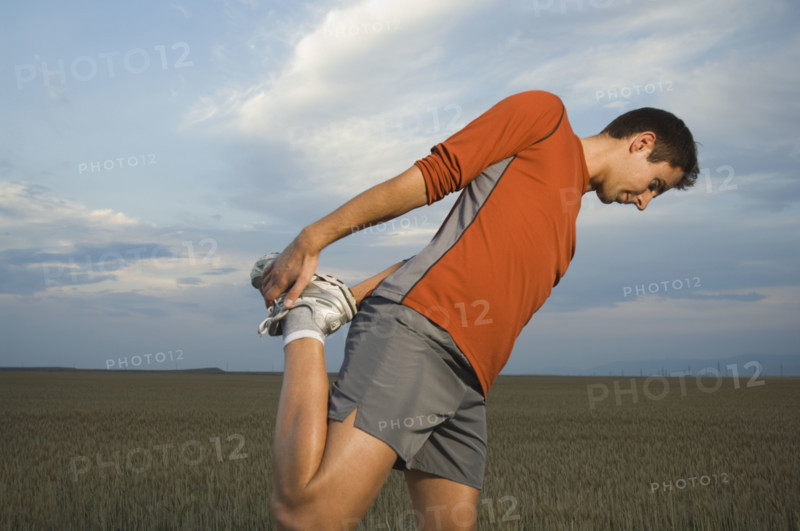 Man in athletic gear stretching. Date : 2007