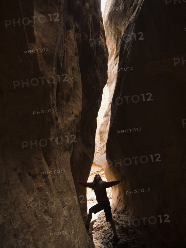 Woman looking up between rock formations. Date : 2007