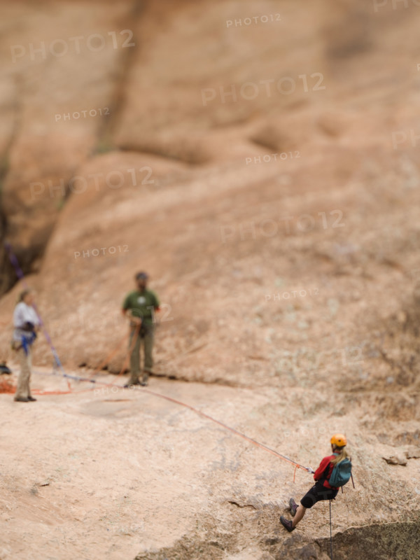 Woman in rappelling gear at top of cliff. Date : 2007