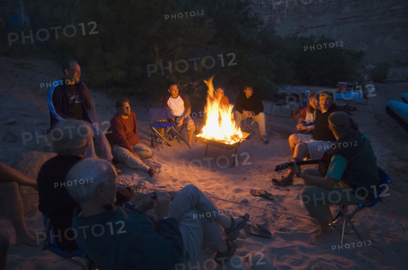 People relaxing around camp fire. Date : 2007