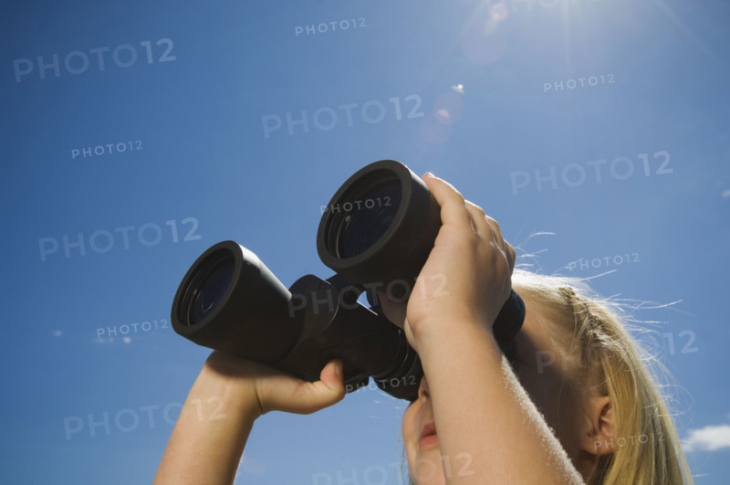 Girl looking through binoculars, Utah, United States. Date : 2007