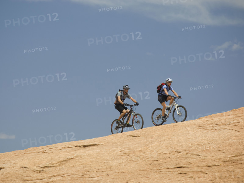 Couple riding mountain bikes in desert. Date : 2007