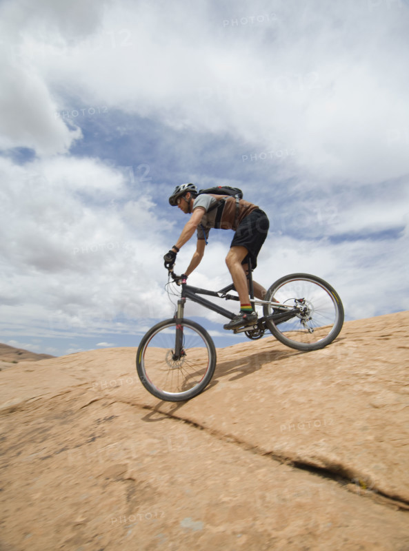 Man riding mountain bike on rock formation. Date : 2007
