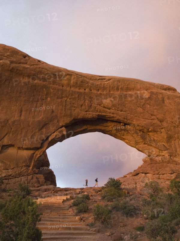 People standing under rock formation. Date : 2007