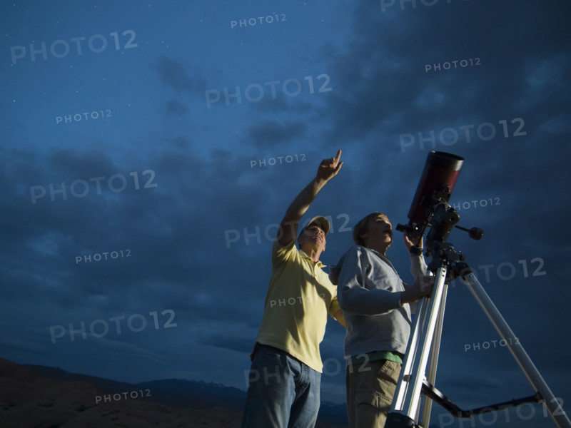 Couple using telescope on tripod. Date : 2007