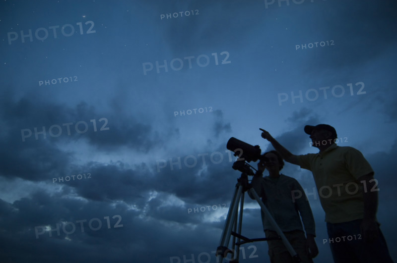Couple using telescope on tripod. Date : 2007