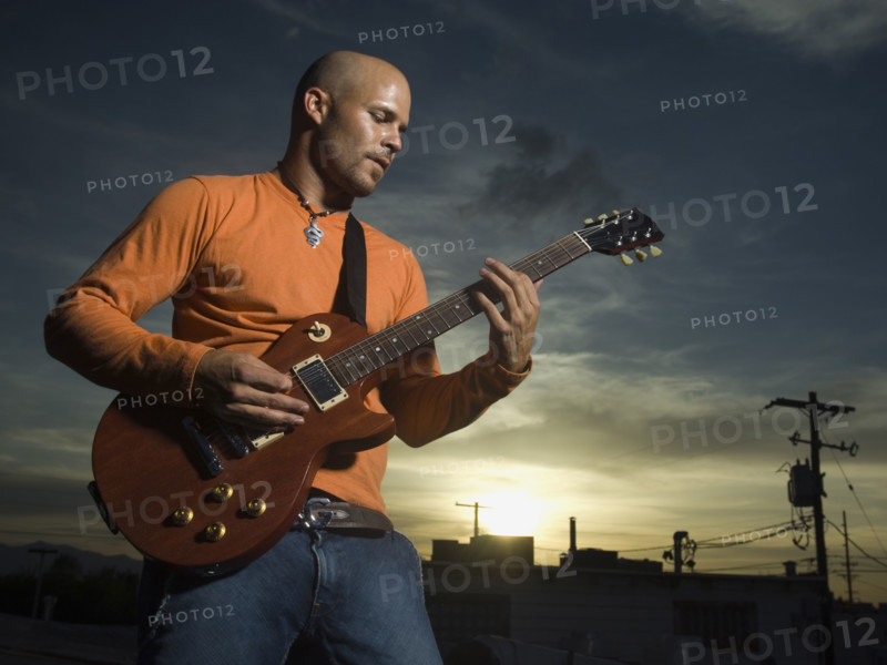 Man playing guitar at dusk. Date : 2007