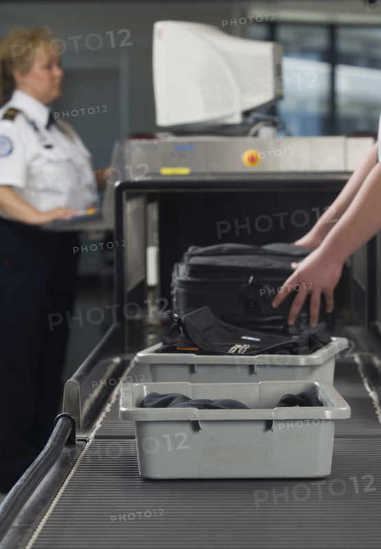 Airport security worker checking baggage. Date : 2007