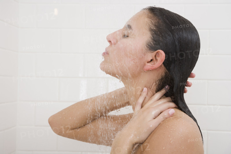 Woman standing under shower.