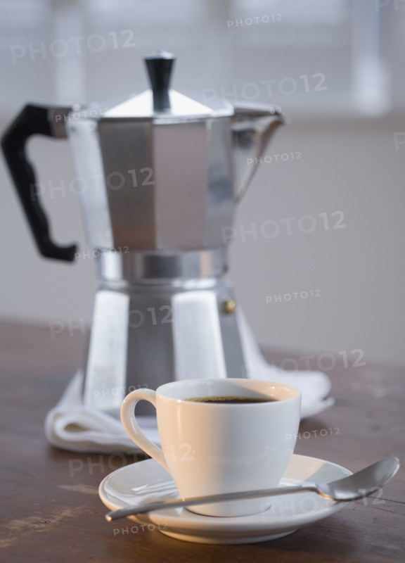 Espresso in front of coffee pot.