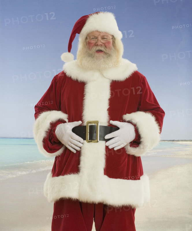 Santa Claus laughing at beach.