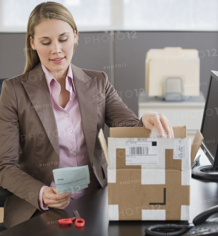Businesswoman opening package.