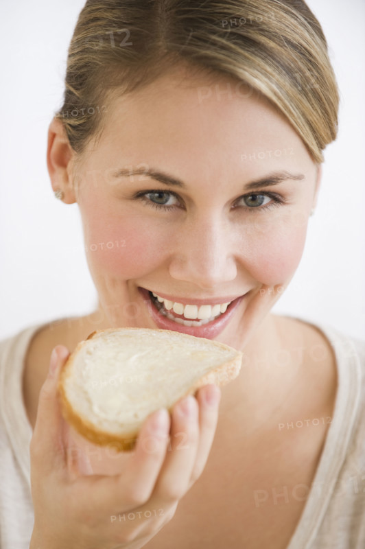 Woman eating bread and butter.