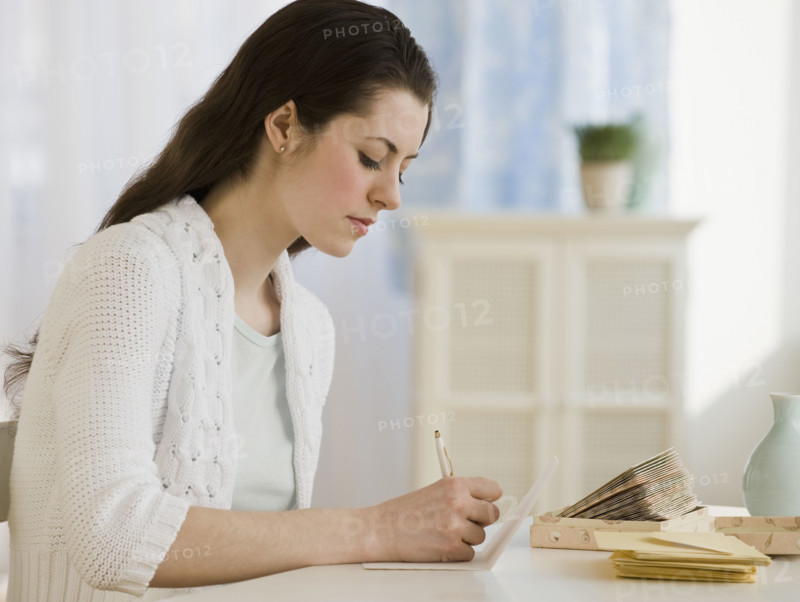 Woman writing at table.